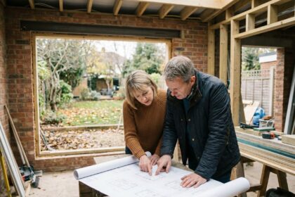 Couple d'adultes examinant des plans dans leur extension en construction